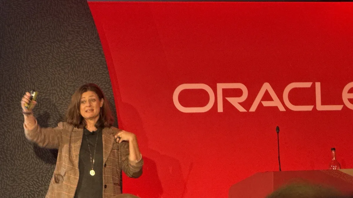 Dr. Leda Glyptis speaking on stage in front of the Oracle backdrop at the Oracle Financial Services Summit in London, October 2026