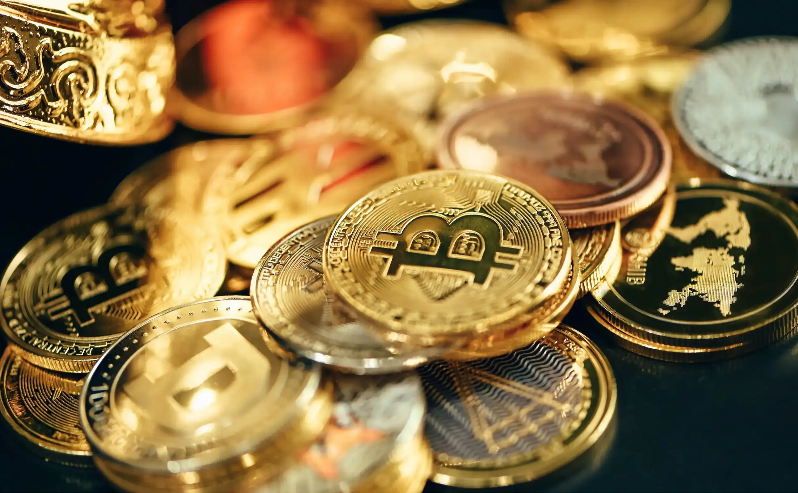 A pile of gold and silver coins sitting on top of a table
